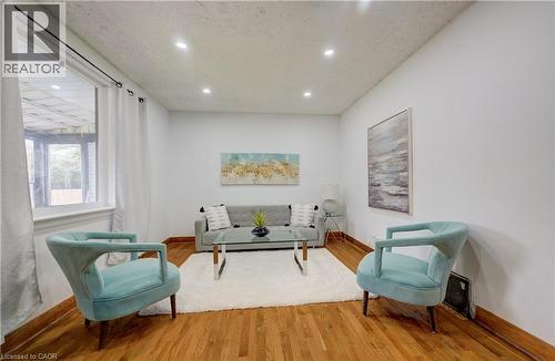 Hardwood-style flooring throughout the room features recessed lighting and white walls - 182 Avalon Place, Kitchener, ON - Indoor