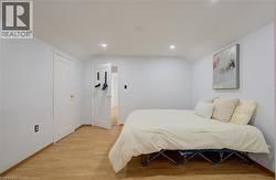 Room featuring wood-finish flooring, recessed lighting, and white baseboards - 