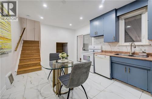 Kitchenette featuring blue cabinetry, a double basin sink, and a white appliance suite - 182 Avalon Place, Kitchener, ON - Indoor Photo Showing Kitchen With Double Sink