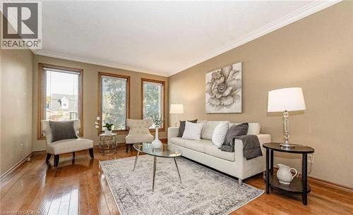 Hardwood flooring, crown molding, three windows, neutral wall tones, and recessed lighting - 28 Walnut Drive, Guelph, ON - Indoor Photo Showing Living Room