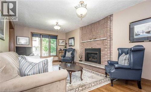 Brick-clad fireplace with a stone hearth and mantel - 28 Walnut Drive, Guelph, ON - Indoor Photo Showing Living Room With Fireplace