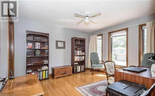 Hardwood flooring, three windows with natural wood trim, light gray wall paint, and a ceiling fan with integrated lighting - 28 Walnut Drive, Guelph, ON - Indoor Photo Showing Office