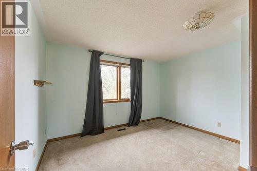 Room featuring a double window with wood-finish trim, light blue painted walls, and textured ceiling - 27 Walmer Gardens, London, ON - Indoor Photo Showing Other Room