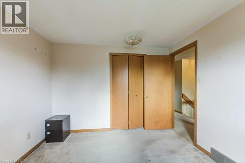 Room featuring light-toned walls, a flush-mount ceiling light fixture, and wood trim details - 27 Walmer Gardens, London, ON - Indoor Photo Showing Other Room
