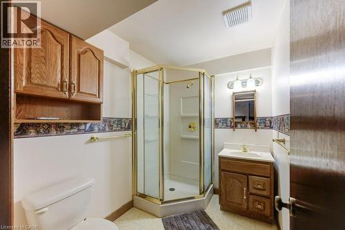 Bathroom with a corner shower enclosure featuring a gold-tone frame and a built-in vanity with a white countertop - 27 Walmer Gardens, London, ON - Indoor Photo Showing Bathroom