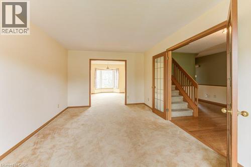 Expansive carpeted room featuring light-toned walls and wood-finish baseboards - 27 Walmer Gardens, London, ON - Indoor Photo Showing Other Room