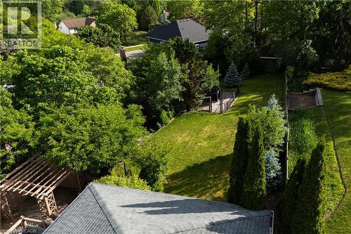 Expansive rear yard featuring a manicured lawn, established landscaping, a wooden pergola, and a visible storage shed - 907 Doon Village Road, Kitchener, ON - Outdoor