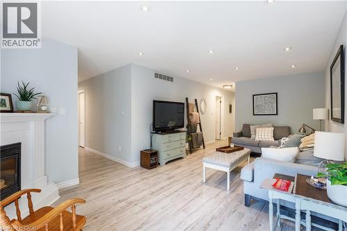 Spacious interior featuring light wood-finish flooring, recessed lighting, and a white fireplace mantel - 907 Doon Village Road, Kitchener, ON - Indoor Photo Showing Living Room With Fireplace