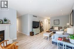 Spacious interior featuring light wood-finish flooring, recessed lighting, and a white fireplace mantel - 