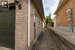Brick exterior featuring a black panel garage door and a side entrance with a gray door - 