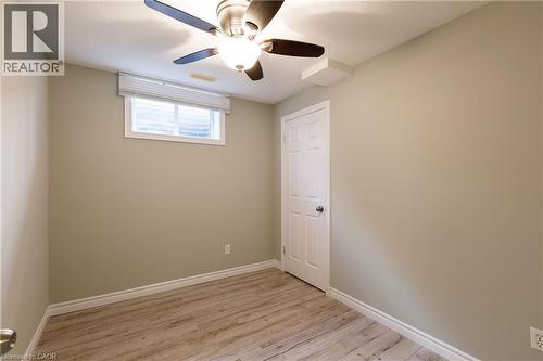 Bright bedroom featuring wood-finish flooring, neutral wall finishes, and a ceiling fan with integrated lighting - 907 Doon Village Road, Kitchener, ON - Indoor Photo Showing Other Room