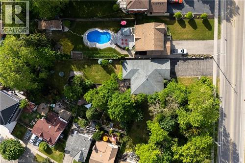 Backyard oasis featuring an in-ground swimming pool, surrounding patio, and expansive lawn - 907 Doon Village Road, Kitchener, ON - Outdoor With View