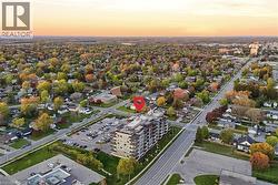 Aerial depiction of a multi-story building featuring multiple balconies and an expansive surface parking lot - 