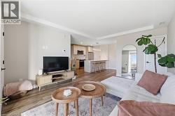 Open-concept living space featuring wood-finish flooring, recessed lighting, and light-colored walls - 
