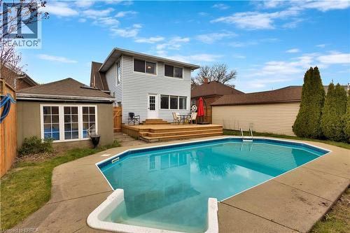 Rear exterior featuring an in-ground swimming pool, concrete pool deck, and a multi-level wood deck - 371 Ottawa Street S, Kitchener, ON - Outdoor