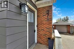 Exterior featuring horizontal siding, brick accents, and an entry door with a multi-pane glass insert - 