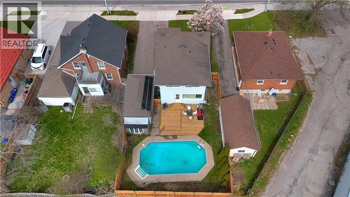 Rear exterior featuring an inground swimming pool, expansive wood deck, and solar panels - 371 Ottawa Street S, Kitchener, ON - Outdoor With In Ground Pool