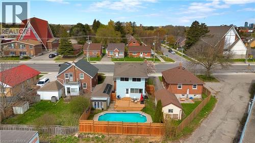 Rear exterior featuring a spacious wood deck, an in-ground swimming pool, and a private wood fence - 371 Ottawa Street S, Kitchener, ON - Outdoor With In Ground Pool