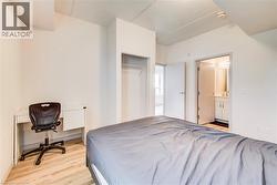 Light wood-finish flooring complements the white walls throughout this room - 