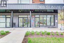 Building entrance featuring a contemporary design with dark brickwork and a prominent overhead canopy - 