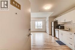 Entry opens to an open-concept living area with wood-finish flooring - 