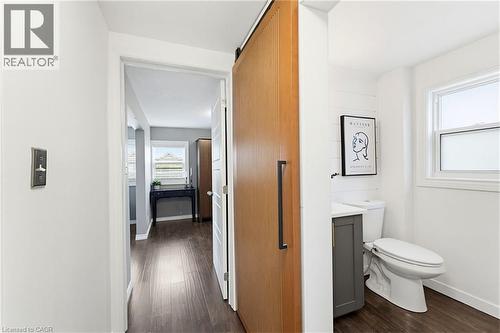 Sliding wood-finish barn door with matte black hardware - 60 Avenue Road, Cambridge, ON - Indoor Photo Showing Bathroom