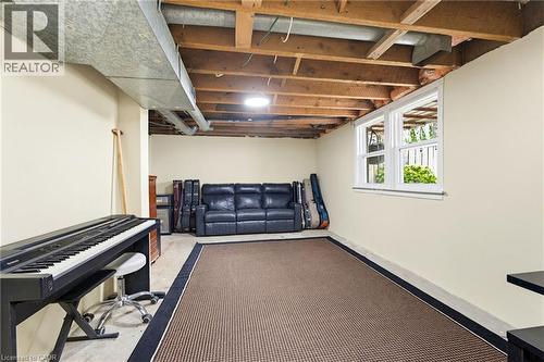 Lower level space featuring exposed ceiling joists and ductwork, painted walls, carpeted floor area, and two double-hung windows - 60 Avenue Road, Cambridge, ON - Indoor