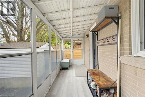 Enclosed sunroom featuring light wood-finish flooring, a white corrugated ceiling, multiple large windows, and a brick exterior wall - 60 Avenue Road, Cambridge, ON -  With Exterior