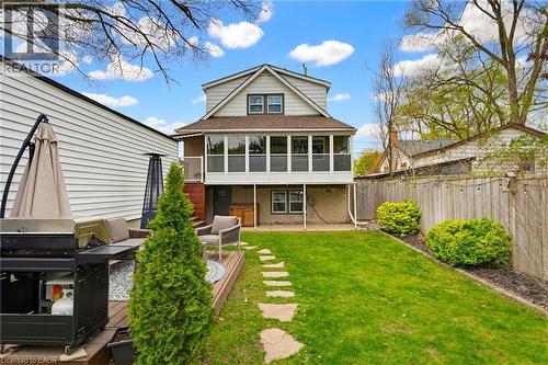 Rear exterior with an upper-level enclosed porch, ground-level patio, and a stone-path leading to a private backyard - 60 Avenue Road, Cambridge, ON - Outdoor