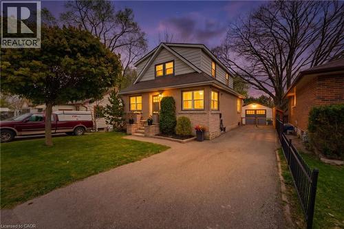Two-story residence featuring a combination of brick and siding, a paved driveway, a detached garage with double doors, and a front walk leading to the entryway - 60 Avenue Road, Cambridge, ON - Outdoor