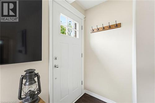 Entryway featuring a white paneled door with glass inserts, wood-finish flooring, and a wall-mounted coat rack - 60 Avenue Road, Cambridge, ON - Indoor Photo Showing Other Room