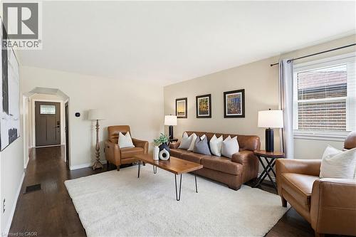 Expansive living area featuring rich wood-finish flooring, a bright window with blinds, and neutral wall tones - 60 Avenue Road, Cambridge, ON - Indoor Photo Showing Living Room