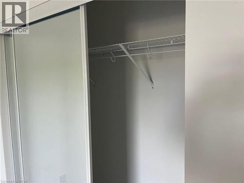 Sliding closet doors featuring a white wire shelving system and hanging rod - 3370 Stella Crescent Unit# 235, Windsor, ON - Indoor With Storage