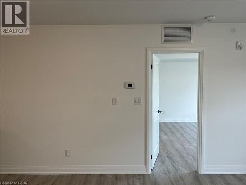 Interior doorway with white trim and a black handle, featuring wood-finish flooring - 3370 Stella Crescent Unit# 235, Windsor, ON - Indoor Photo Showing Other Room