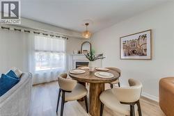 Dining area featuring wood-finish flooring and a decorative chandelier - 