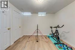 Finished interior space featuring wood-finish flooring, white baseboards, and bright white walls - 