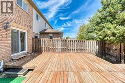 Expansive wood deck with a privacy fence, offering direct access to the interior via a sliding glass door - 