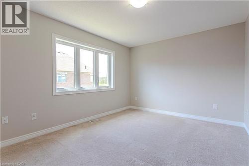 Neutral-toned room with plush carpet flooring, white baseboards, and a three-pane window - 3896 Tufgar Crescent, Burlington, ON - Indoor Photo Showing Other Room