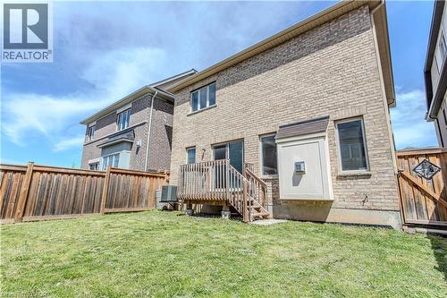 Rear exterior featuring a brick facade, private wooden fence, and a raised wooden deck with stairs to the yard - 3896 Tufgar Crescent, Burlington, ON - Outdoor
