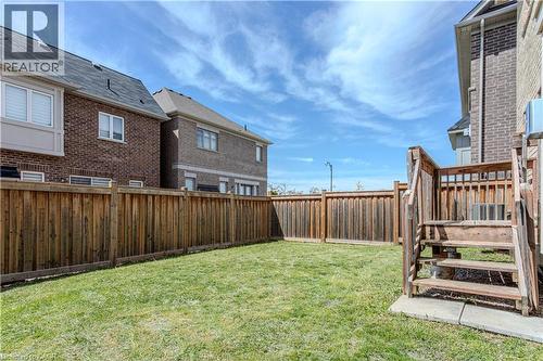 Expansive fenced backyard featuring a grassy lawn and a wooden deck with stairs - 3896 Tufgar Crescent, Burlington, ON - Outdoor