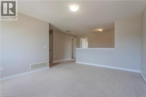 Spacious carpeted room featuring light gray walls, white baseboards, and a semi-flush mount ceiling light - 3896 Tufgar Crescent, Burlington, ON - Indoor Photo Showing Other Room