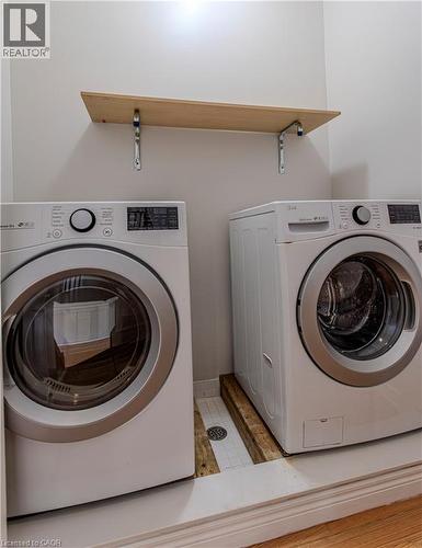 Dedicated laundry area featuring a wall-mounted shelving unit with wood-finish surface, light gray walls, and white baseboards - 3896 Tufgar Crescent, Burlington, ON - Indoor Photo Showing Laundry Room