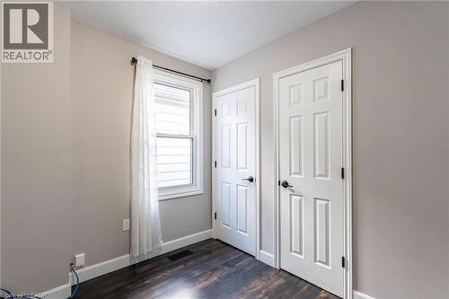 Unfurnished bedroom with baseboards and dark wood-type flooring - 222 Kensington Avenue N, Hamilton, ON - Indoor Photo Showing Other Room