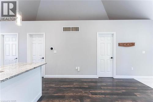 Unfurnished living room featuring dark wood finished floors and baseboards - 222 Kensington Avenue N, Hamilton, ON - Indoor Photo Showing Other Room