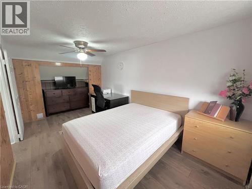 Room featuring wood-finish flooring, a ceiling fan with integrated lighting, and white painted walls - 56 Eastvale Place, Hamilton, ON - Indoor Photo Showing Bedroom