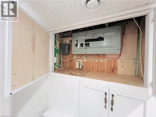 Utility access panel featuring a visible electrical service panel and concealed storage below - 56 Eastvale Place, Hamilton, ON - Indoor