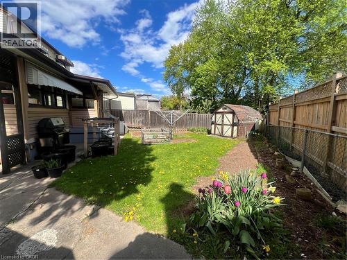 Expansive backyard featuring a lush lawn, mature trees, a garden shed, and established garden beds - 56 Eastvale Place, Hamilton, ON - Outdoor