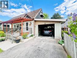 Exterior featuring a stone facade, wood pergola, covered front porch, and an attached carport - 