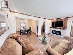 Spacious living area featuring wood-finish flooring, recessed lighting, and crown molding - 