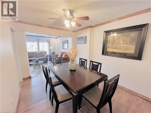Dining area featuring wood-finish flooring, crown molding, and a ceiling fan with integrated lighting - 56 Eastvale Place, Hamilton, ON - Indoor Photo Showing Dining Room